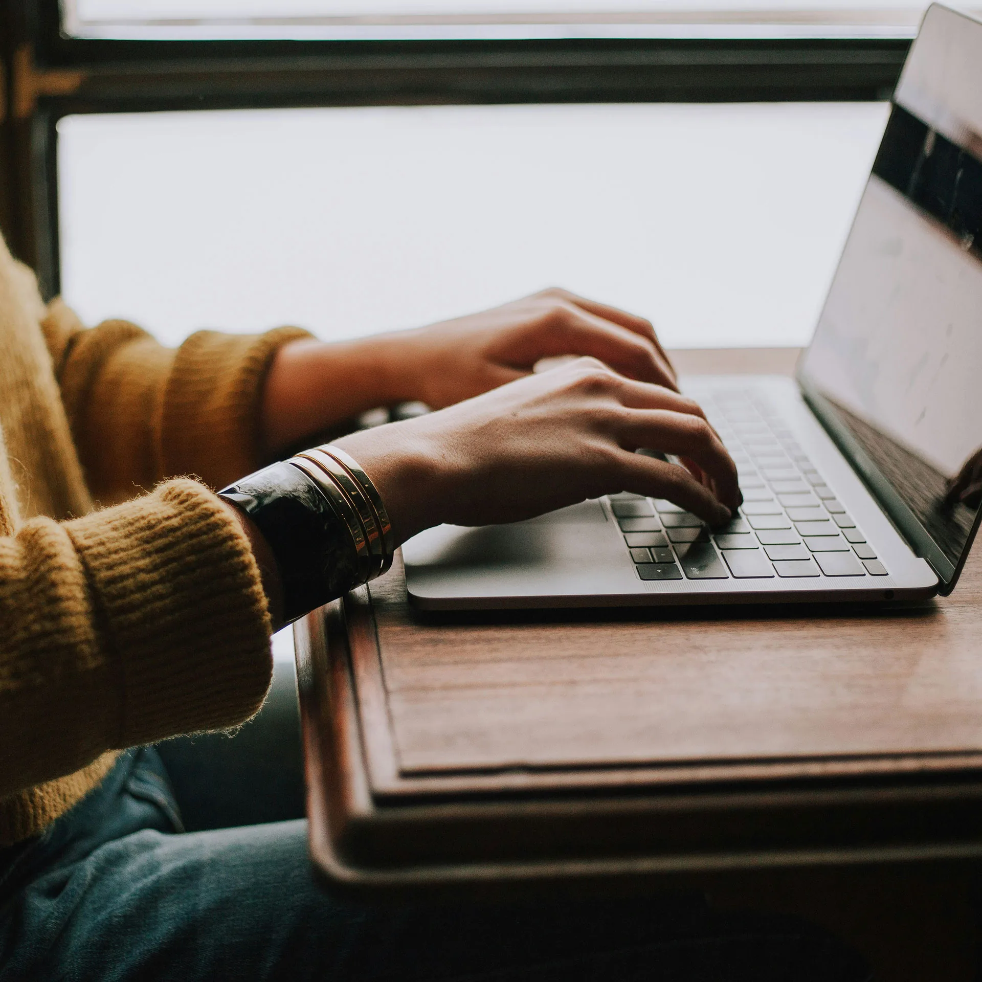 Närbild händer på kvinna som arbetar på laptop